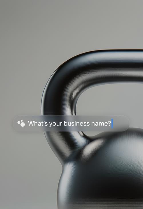 Una foto ravvicinata di un kettlebell nero su sfondo grigio, con una barra di ricerca in sovrimpressione in cui si chiede "Qual è il nome della tua attività?" La barra di ricerca include una piccola icona IA a tre punti e un cursore lampeggiante, che suggerisce un campo di immissione interattivo per il nome dell'azienda.